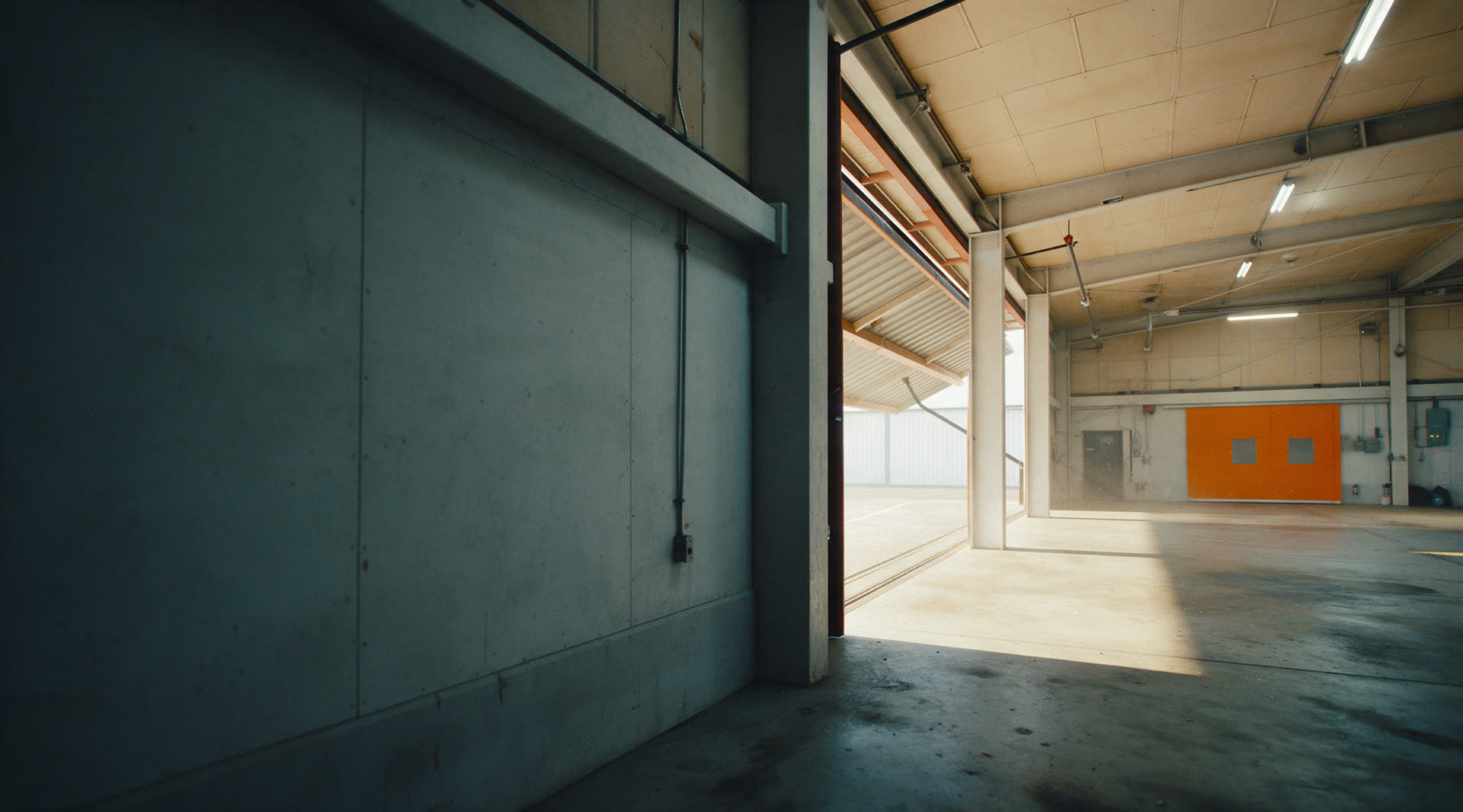 Hangar de treino com marca laranja de instrução ao fundo.